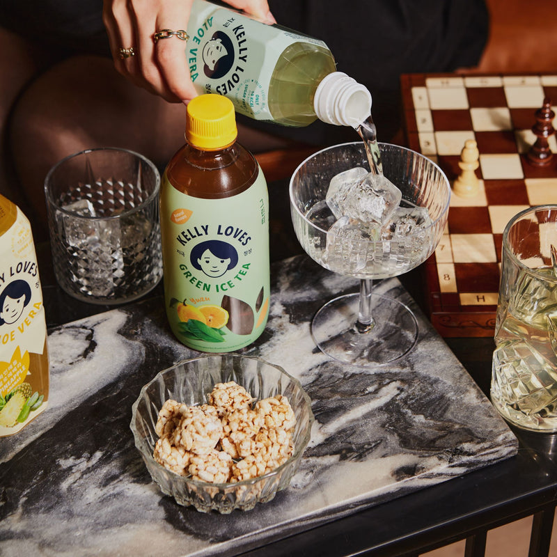 Healthy Korean beverages, sugar-free Aloe Vera Drink lifestyle image with Green Ice Tea Drink in cocktail glass with Brown Rice Snacks